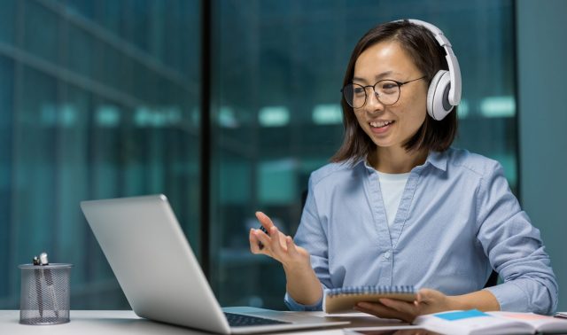 businesswoman with headphones engaged in an educational webinar