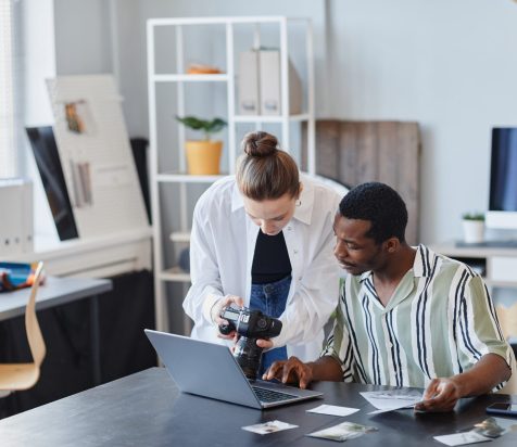 Two Photographers Using Laptop