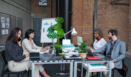 businesspeople sitting and working at desk in office, cooperation and coworking concept.